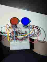 Breadboard prototype with ESP32, jumper wires, and two round displays showing different colors